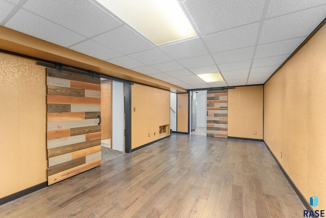 basement with hardwood / wood-style floors and a drop ceiling