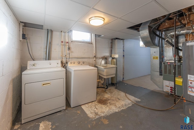 basement featuring sink, a paneled ceiling, and washing machine and clothes dryer