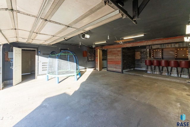 garage featuring a garage door opener and a trampoline