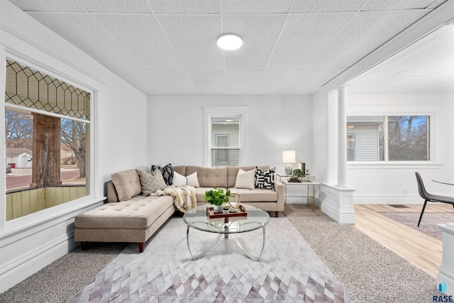 living room with decorative columns, hardwood / wood-style flooring, and a wealth of natural light