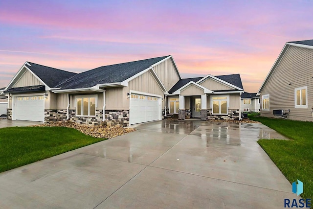 craftsman house featuring central AC, a garage, and a yard