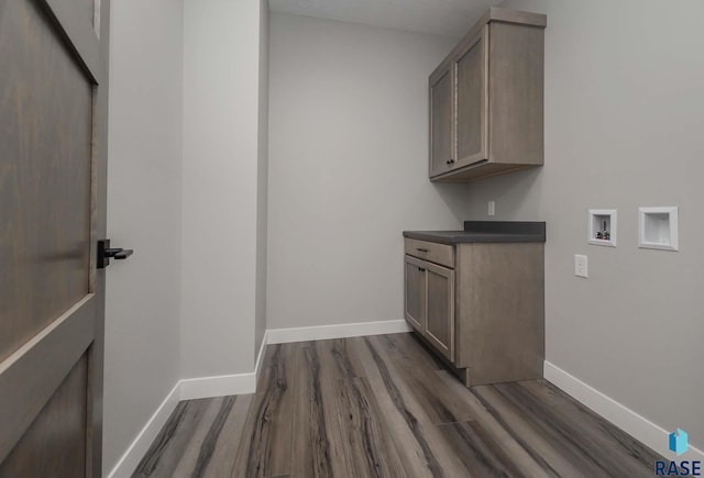 clothes washing area featuring cabinets, hookup for a washing machine, and dark hardwood / wood-style flooring