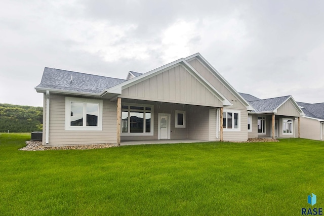 rear view of property featuring a patio and a lawn