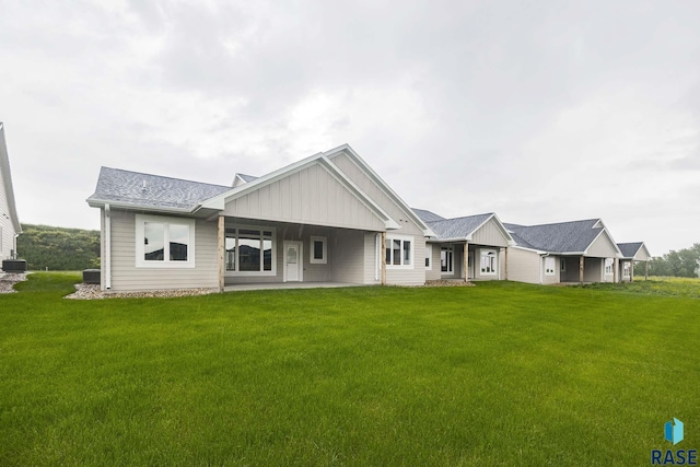 back of property featuring a yard and central air condition unit