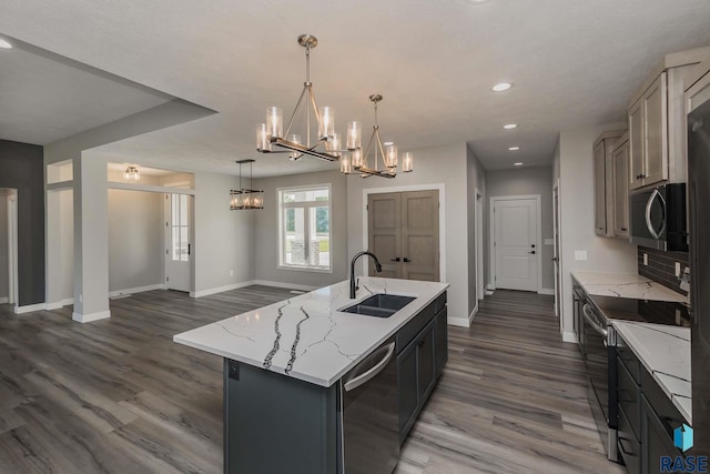 kitchen featuring pendant lighting, sink, a kitchen island with sink, an inviting chandelier, and stainless steel appliances