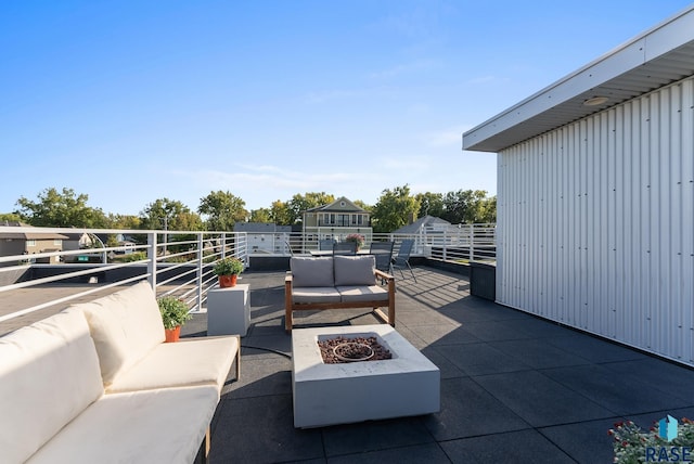 view of patio with a balcony and an outdoor living space with a fire pit