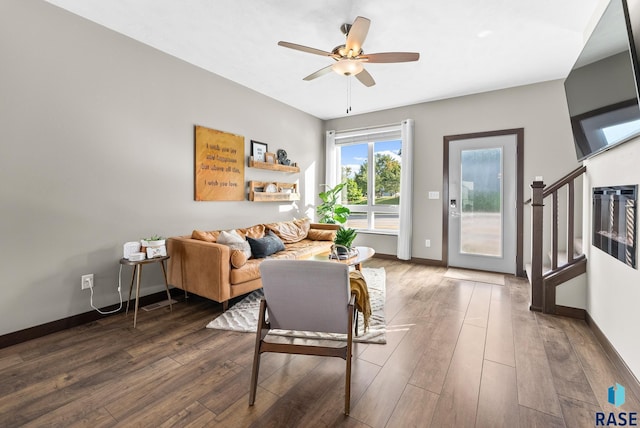 living room with ceiling fan and dark hardwood / wood-style flooring