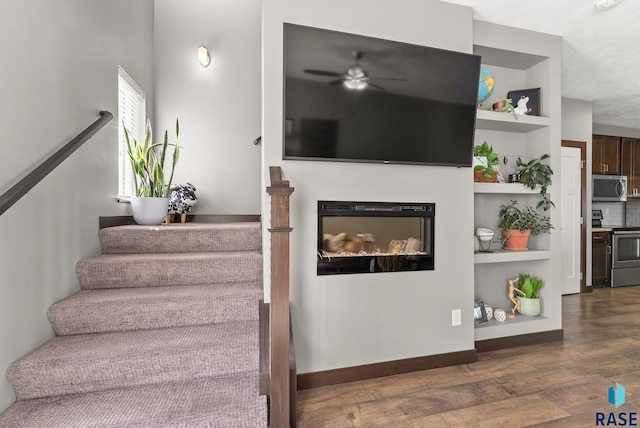 staircase featuring hardwood / wood-style floors and ceiling fan