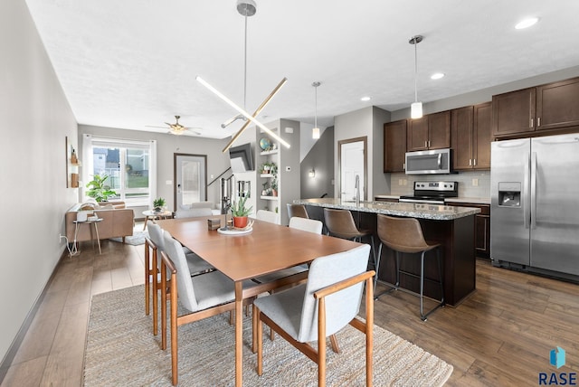 dining area featuring dark hardwood / wood-style floors, sink, and ceiling fan