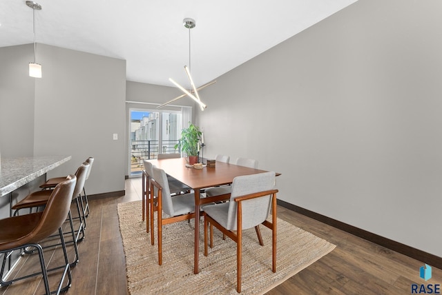 dining area featuring lofted ceiling and dark hardwood / wood-style flooring