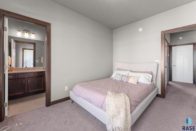 bedroom featuring ensuite bath and light colored carpet