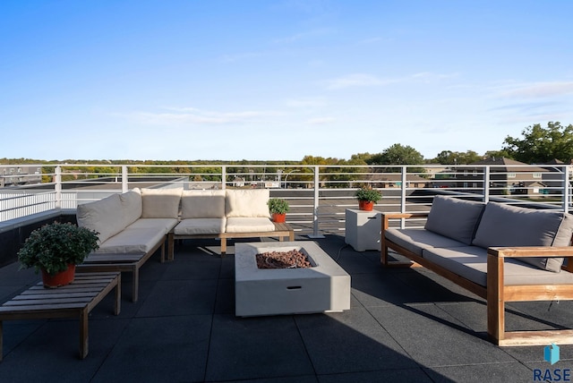 view of patio featuring a balcony and an outdoor living space with a fire pit