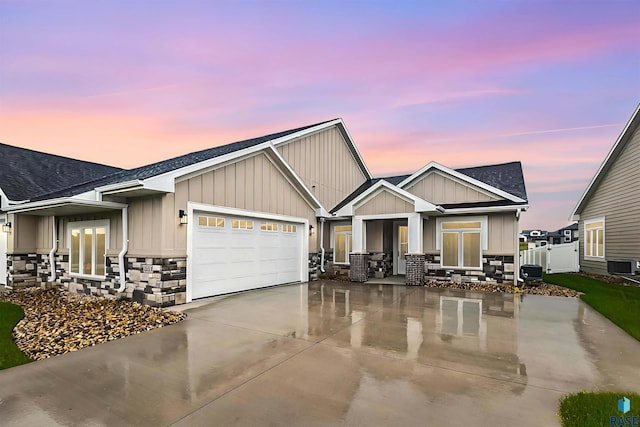 craftsman-style home with cooling unit and a garage