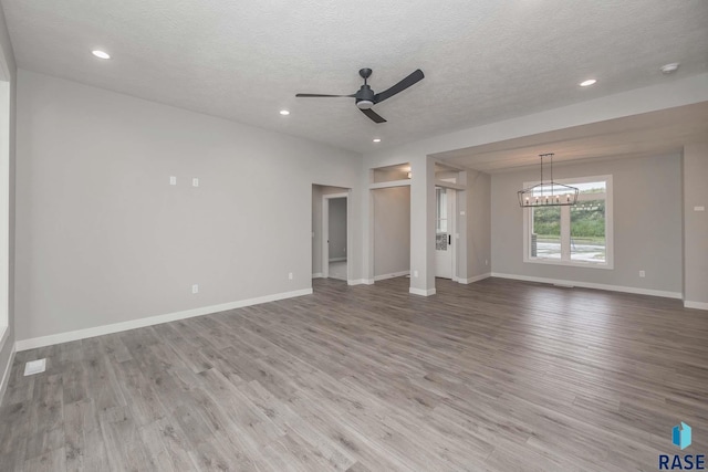 unfurnished living room featuring ceiling fan, a textured ceiling, and light wood-type flooring