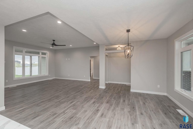 unfurnished living room with wood-type flooring, plenty of natural light, and ceiling fan