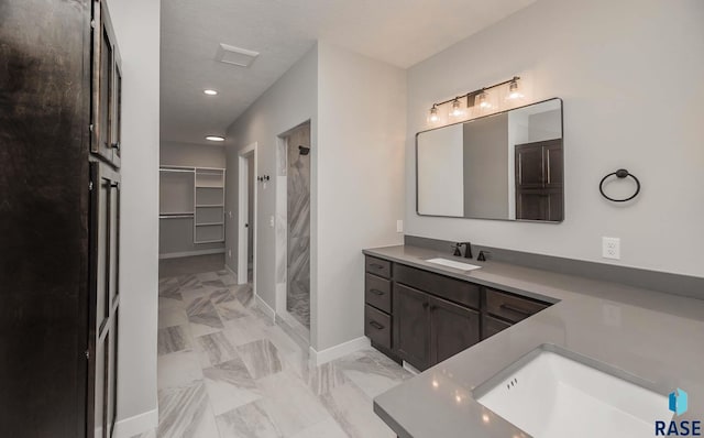 bathroom with vanity, a textured ceiling, and walk in shower