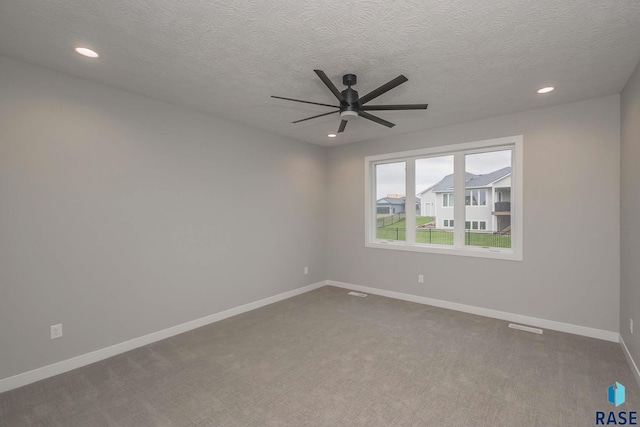 carpeted spare room with ceiling fan and a textured ceiling