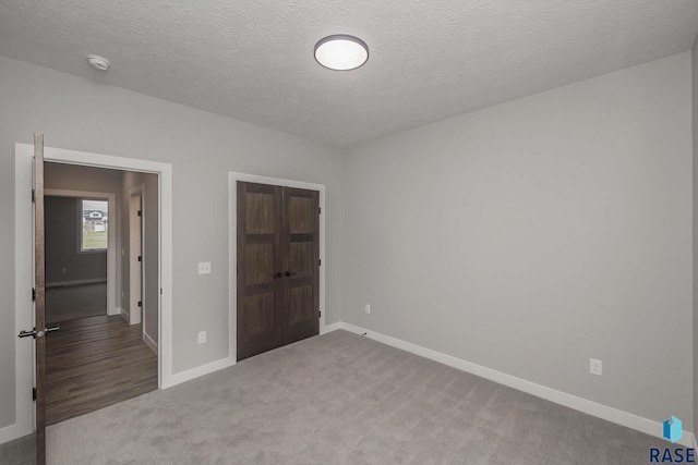 unfurnished bedroom with carpet flooring and a textured ceiling