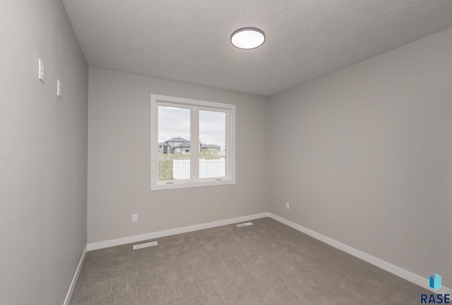 spare room with carpet floors and a textured ceiling