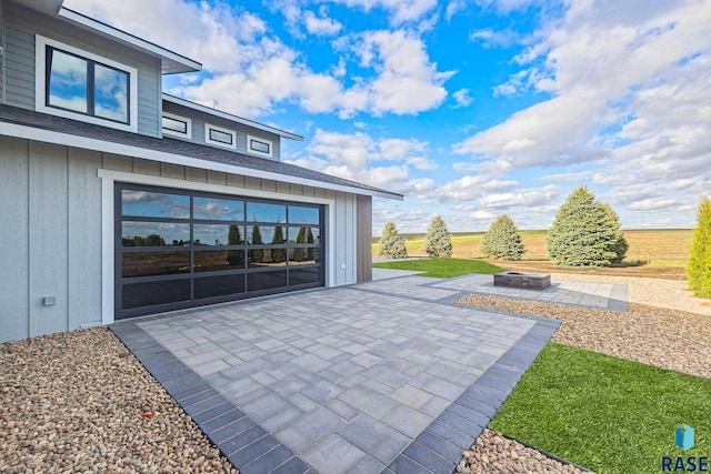 view of patio with a garage and a fire pit