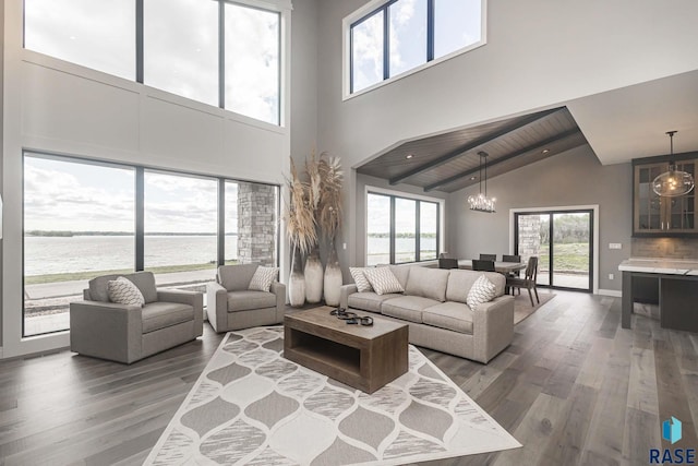 living room featuring dark wood-type flooring, a water view, high vaulted ceiling, wooden ceiling, and a notable chandelier