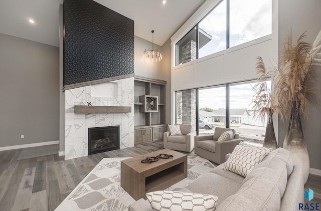 living room featuring a high end fireplace, high vaulted ceiling, and wood-type flooring