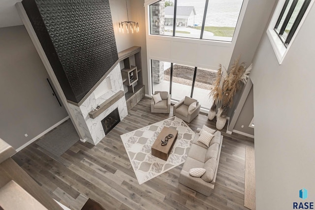 living room featuring hardwood / wood-style floors, a fireplace, and a high ceiling