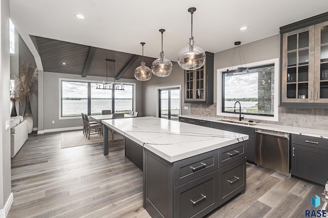 kitchen featuring dishwasher, sink, decorative backsplash, hanging light fixtures, and a center island