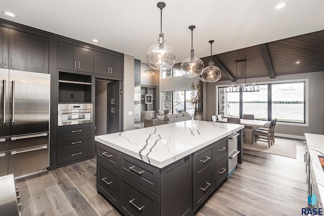 kitchen featuring hanging light fixtures, hardwood / wood-style flooring, a center island, and appliances with stainless steel finishes