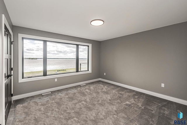 carpeted empty room with a water view