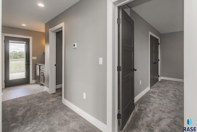 hallway featuring dark colored carpet