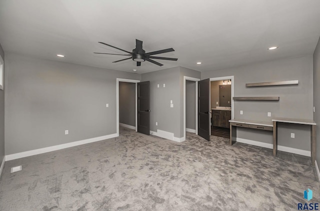 unfurnished bedroom featuring ensuite bath, carpet floors, and ceiling fan