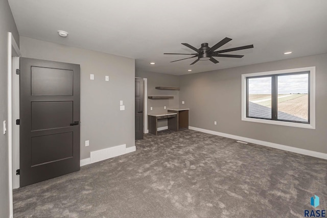 unfurnished living room with ceiling fan and dark carpet