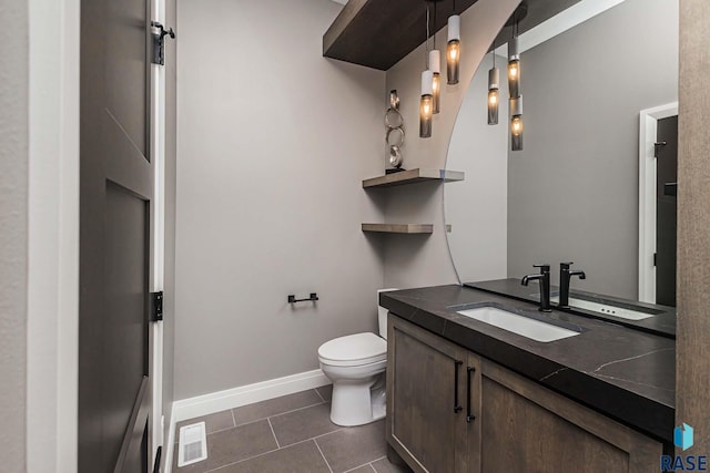 bathroom featuring vanity, tile patterned floors, and toilet