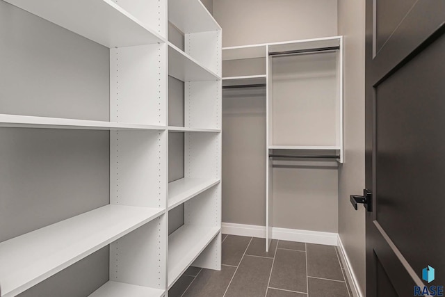 walk in closet with dark tile patterned floors