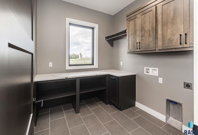 laundry area featuring cabinets, hookup for a washing machine, hookup for an electric dryer, and dark tile patterned floors