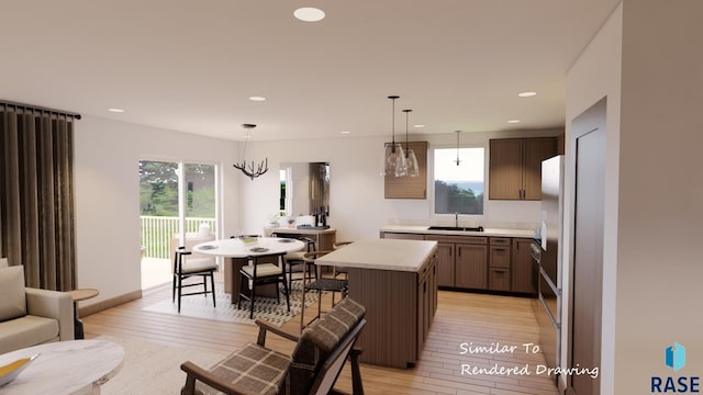 kitchen featuring light wood-style flooring, light countertops, a sink, and a kitchen island