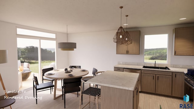 kitchen featuring light countertops, a sink, light wood-style floors, hanging light fixtures, and a kitchen breakfast bar
