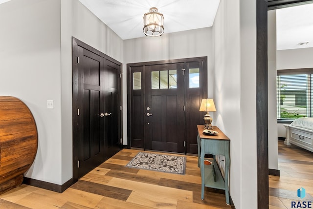 foyer featuring an inviting chandelier and light hardwood / wood-style flooring