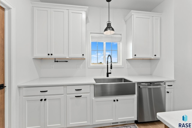 kitchen with sink, dishwasher, pendant lighting, light hardwood / wood-style floors, and white cabinets