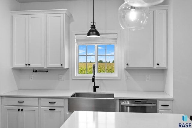 kitchen with dishwasher, sink, pendant lighting, and white cabinets