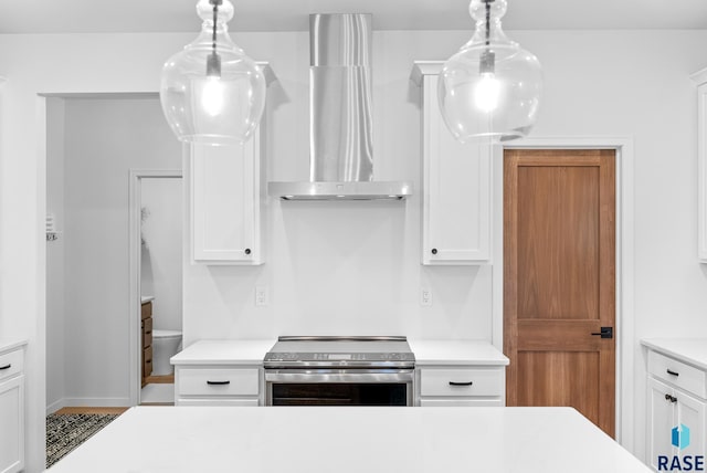 kitchen with white cabinetry, decorative light fixtures, and stainless steel electric range