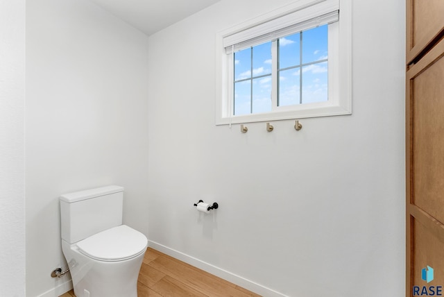 bathroom with hardwood / wood-style floors and toilet