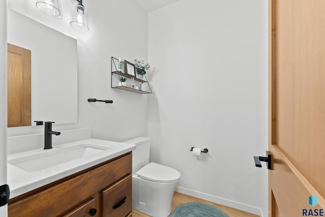 bathroom with vanity, wood-type flooring, and toilet