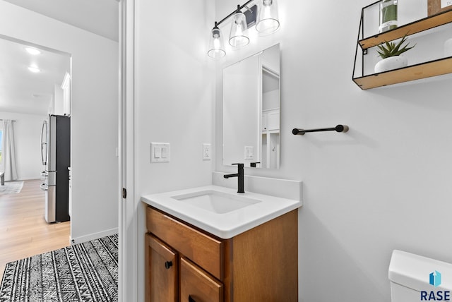 bathroom with vanity, hardwood / wood-style floors, and toilet