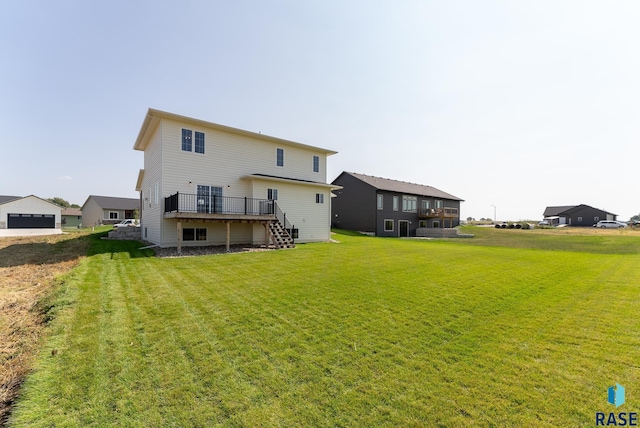 rear view of house with a wooden deck and a yard