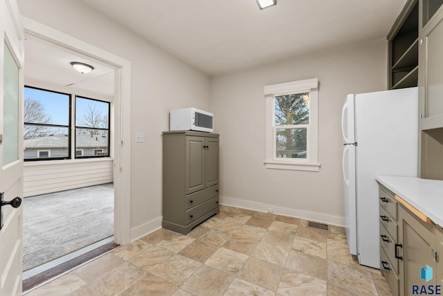 interior space featuring gray cabinetry, white appliances, and plenty of natural light