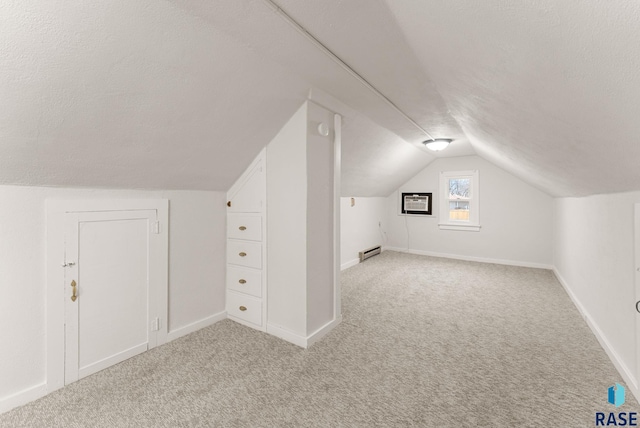 bonus room with light colored carpet, vaulted ceiling, a textured ceiling, and a baseboard heating unit