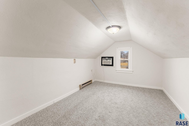 bonus room featuring vaulted ceiling, a wall mounted air conditioner, carpet, baseboard heating, and a textured ceiling