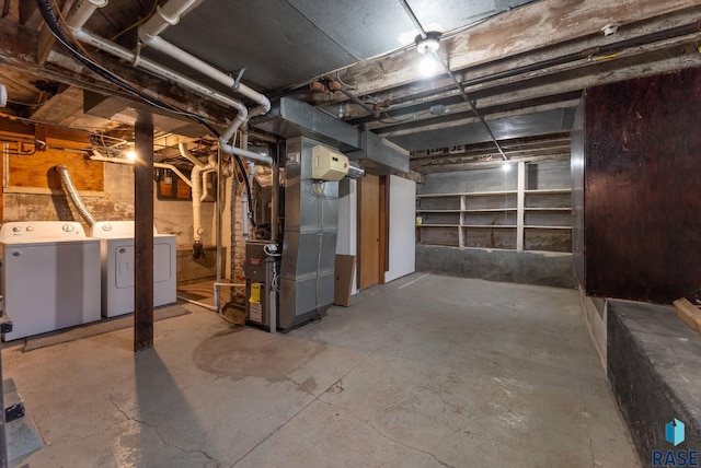 basement featuring heating unit and washer and clothes dryer